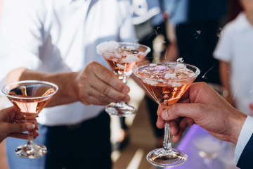  Hands holding the glasses of champagne and wine making a toast.