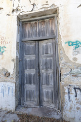 Fototapeta na wymiar Alte verfallene Holztür mit brüchigem Mauerwerk