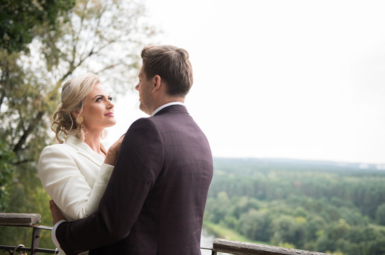Romantic newlyweds exploring views from balcony