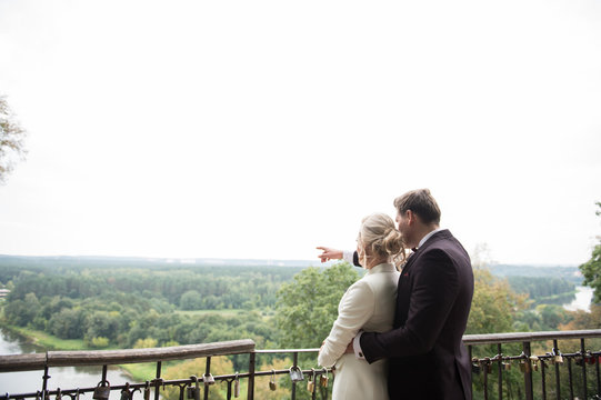 Romantic newlyweds exploring views from balcony