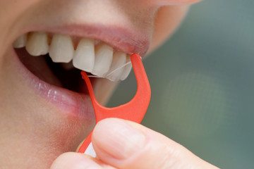Woman cleaning her teeth with orthodontic flosser