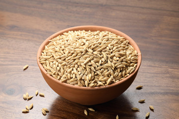 Close up of Hulled Barley in a Earthen Bowl on Wooden Background