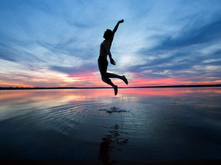 Mann springt hoch aus den Wasser 
