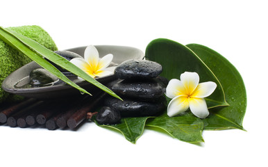 spa tropical leaves and flowers and black stones for healthy therapy