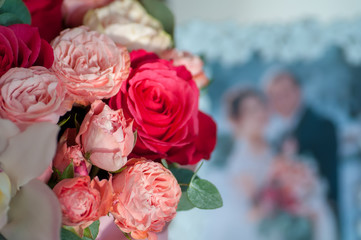 Bridal bouquet near photo of newlyweds in frame