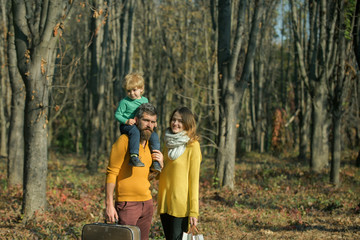 Young family of mother, father and son walk in woods on vacation. Little child and parents on vacation. Enjoying time together