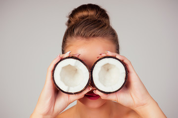 Beautiful young blonde hairstyle girl with coconut in her hand shoulders naked bare in the studio...