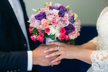 Obraz na płótnie Canvas Weddin bouquet in newlyweds hands