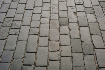 Abstract background of old cobblestone pavement close-up.