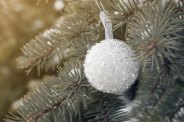white beautiful ball on a Christmas tree, christmas decoration, sun ray, christmas concept