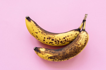 Overripe bananas on pink background, horizontal, top view