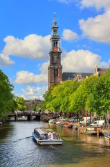 Küchenrückwand glas motiv Canalboat tour at the UNESCO world heritage Prinsengracht canal with the Westerkerk (Western church) on a sunny summer day with blue sky and clouds © dennisvdwater