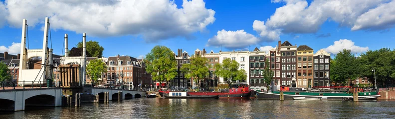 Foto op Plexiglas Prachtig panoramisch panorama van de magere brug (magere brug) terwijl open over de rivier de Amstel in Amsterdam, Nederland, op een zonnige zomerdag met wat wolken © dennisvdwater