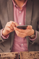 Modern business man using cellphone outdoors.