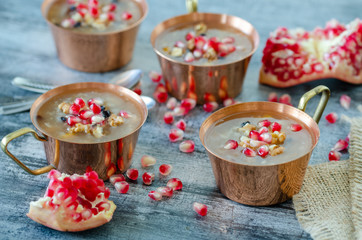 Fototapeta na wymiar Turkish traditional dessert Ashura, Noah's pudding in copper bowl.