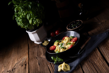 ravioli with spinach filling, grated cheese and cocktail tomatoes