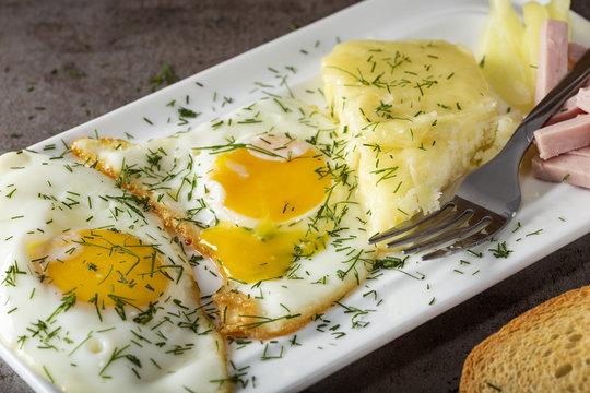 Fried eggs with melted Romanian cheese called cas