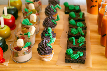 Halloween style party candy bar and decorations - brownies, cupcakes, mousse, caramel apples