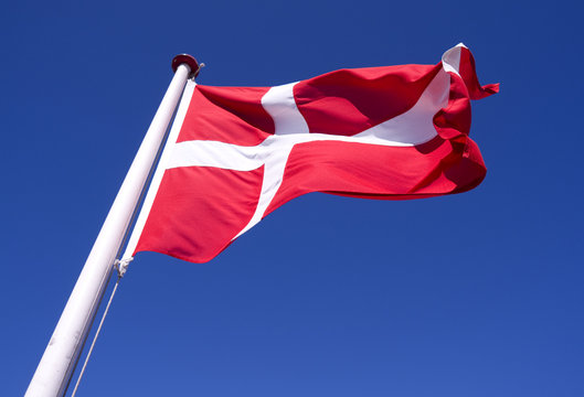 Flags / Laesoe / Denmark: The Danish national flag &bdquo;Dannebrog&ldquo; is fluttering in the gusty coastal wind on Laesoe island