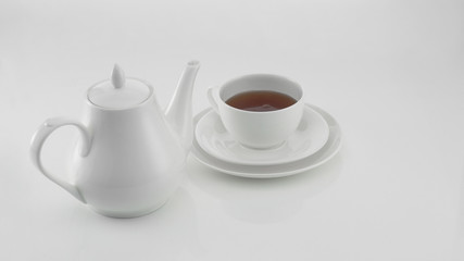 white ceramic teapot with cup on light background