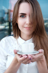 Redhead white girl in white shirt drinking coffee