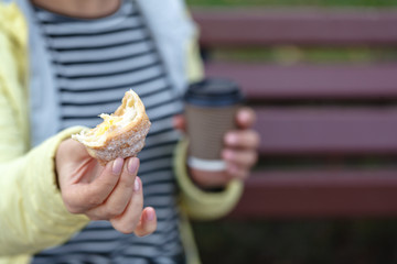 Beautiful woman holding coffee cup and croissant