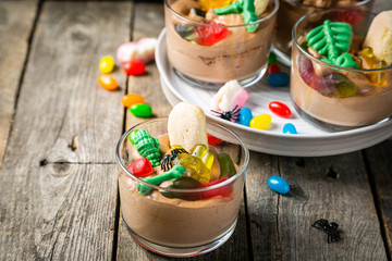 Halloween style sweets - chocolate mousse with gelly snakes, rustic background