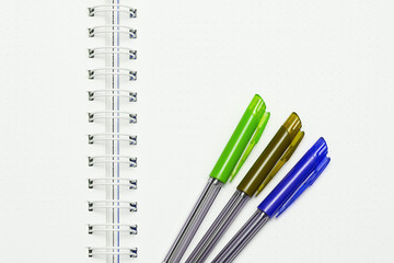 A notebook with tree pens