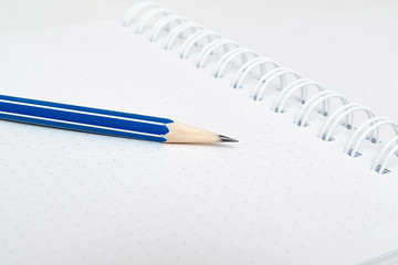 a bleu pencil and white notebook