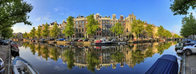 Fotobehang Beautiful 180 degree panoramic panorama of the UNESCO world heritage Keizersgracht canal  in Amsterdam, the Netherlands, on a sunny summer day with a blue sky and mirror reflection © dennisvdwater