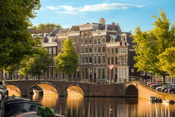 Fotobehang Beautiful view of the iconic UNESCO world heritage Keizersgracht canal  in Amsterdam, the Netherlands, on a sunny summer morning with sunshine, a blue sky and reflection © dennisvdwater