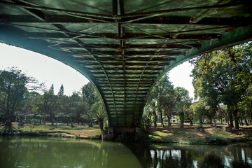 Bellow view of a ibirapuera's bridge with trees in the background and a big lake in the ground, in São Paulo. City, tourism, peaceful place, parks, is the concept