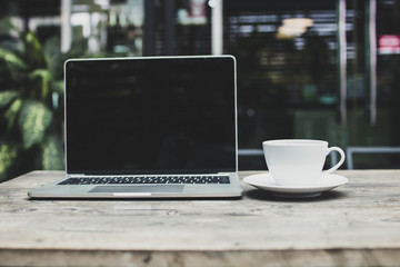 coffee and laptop on wood table in cafe