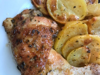 Baked chicken and potatoes marinated with garlic and parsley in the oven