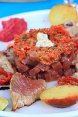 Plate of red tuna with its vegetable garnish in a french restaurant
