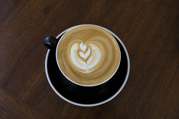 Hot coffee cappuccino latte art top view on wooden table