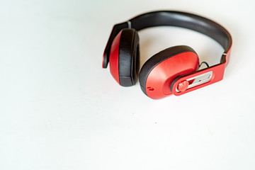 Red headphones on a white-grey background. Photo with small noise and soft similar focus.