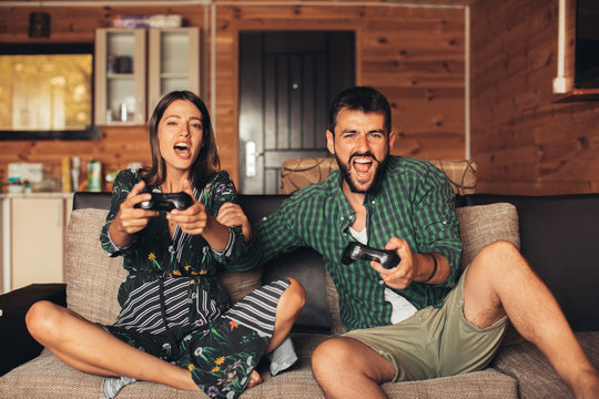 Young Couple Playing Video Game Together At Home