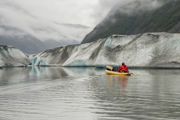 A Kayaker gives scale to Valdez Glacier in Alaska