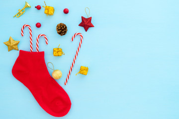 Christmas composition.  Red christmas stocking with decoration on blue background.  Creative flat lay, top view design