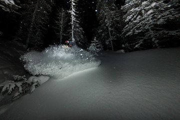 freerider rides at night on powder snow blows up