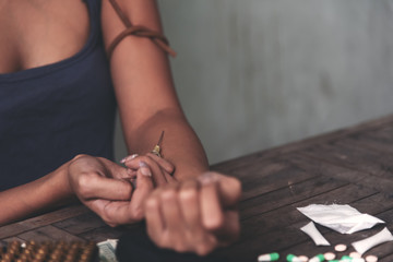 Addict women hands making syringe injection of heroin.