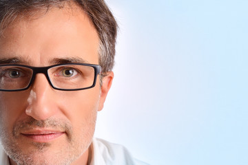 Obraz premium Attractive middle-aged man with eyeglasses blue background detail