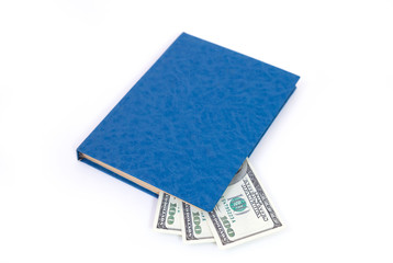 Closeup of a blue book with 100 us dollar banknotes inside, isolated on white background