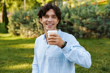 Fototapeta premium Smiling young casual man drinking coffee