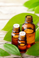 cinnamon leaf oil and fresh cinnamon leaves on the wooden board