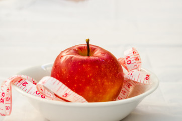 red apple with measurig tape, weigh loss concept