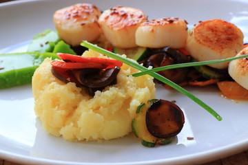 Plate of scallops cooked with its vegetables garnish in a french gastronomic restaurant
