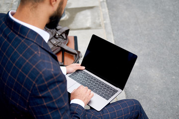 Business Man Working on Laptop Computer. Man in Business Suit on outdoors
