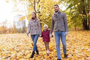 Naklejka na ściany i meble family, season and people concept - happy mother, father and little daughter walking at autumn park